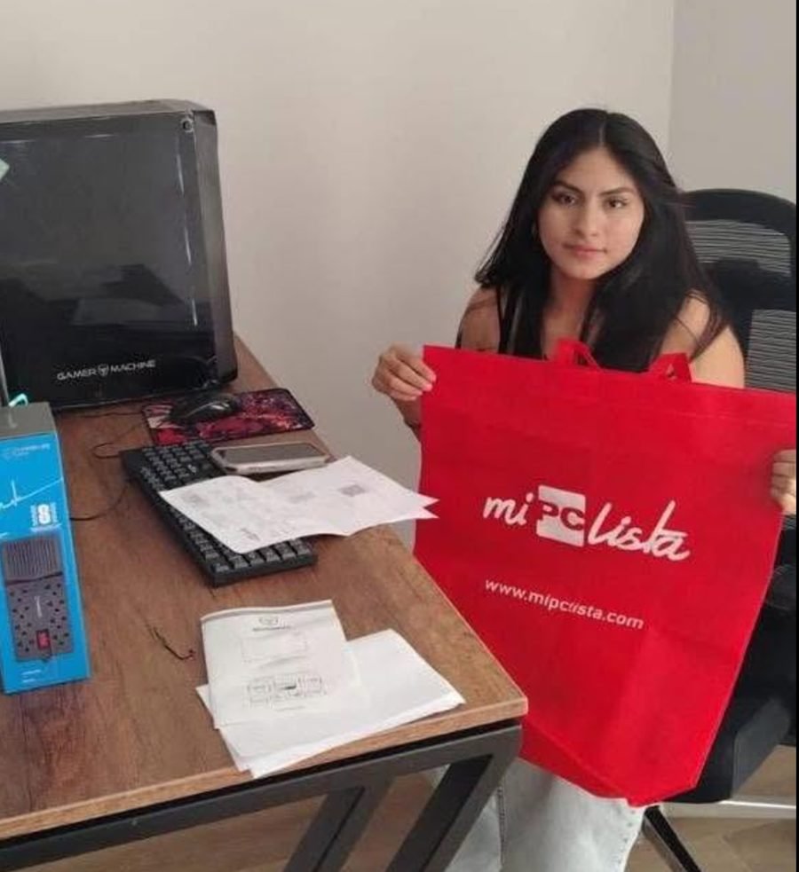 Clienta con la bolsa de su compra junto a su PC en su escritorio