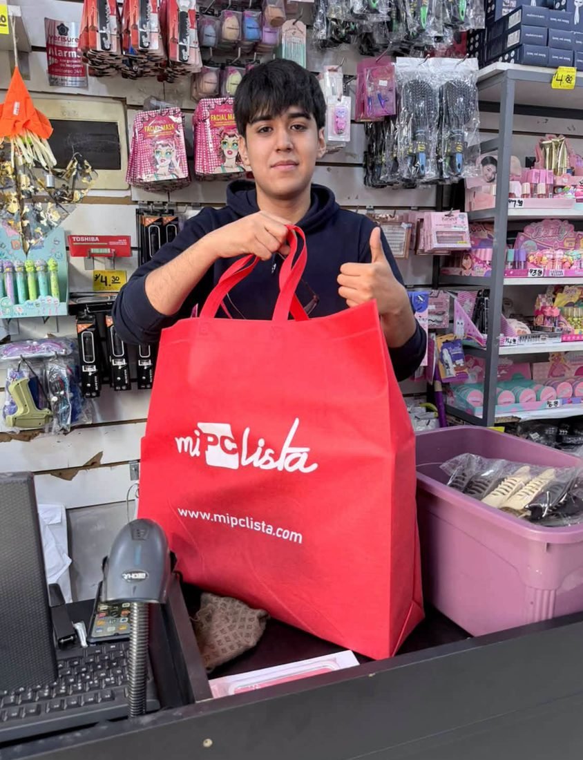 Cliente joven recibiendo su PC gamer en el mostrador de la tienda